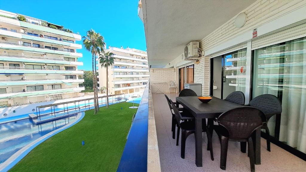 萨洛Apartamentos Riviera Niza 05的一个带桌椅的阳台和一个游泳池