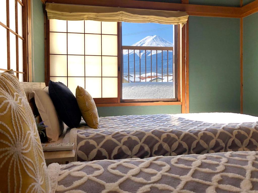 富士河口湖OriOri House Hotel Mt Fuji view 全室富士山ビューの貸切り宿 折々的一间卧室配有一张床和一个享有山景的窗户