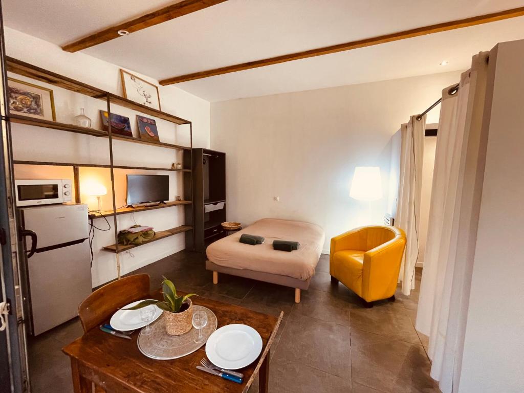 尼姆Charmant studio loft - Mas Bois Fontaine的小房间设有桌子和黄色椅子