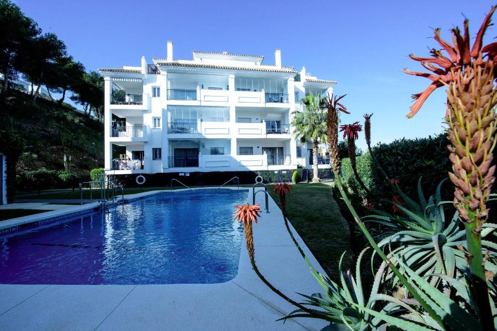 卡拉德米哈斯Apartment Summer Vibes Miraflores - La Cala de Mijas的一座白色的大建筑,前面设有一个游泳池