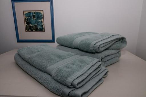 贝克斯希尔Bexhill Luxury Sea Stay Flat 2的桌子上堆着的毛巾
