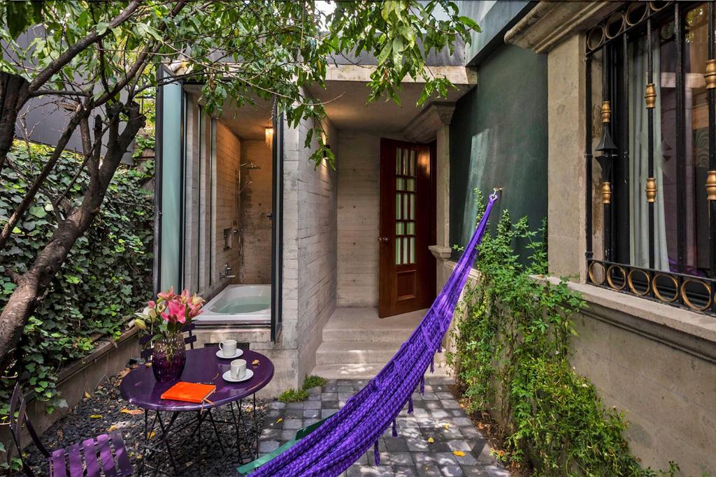 墨西哥城Pug Seal Polanco Anatole France的紫色的吊床,位于带桌子的房子外