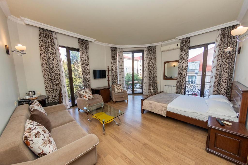 巴统艾菲尔酒店的一间大卧室,配有一张床和一张沙发