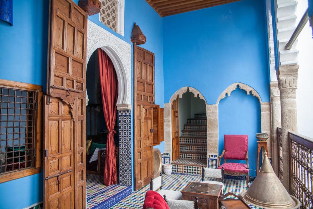拉巴特Dar Shaeir的一间拥有蓝色墙壁和木门的客房