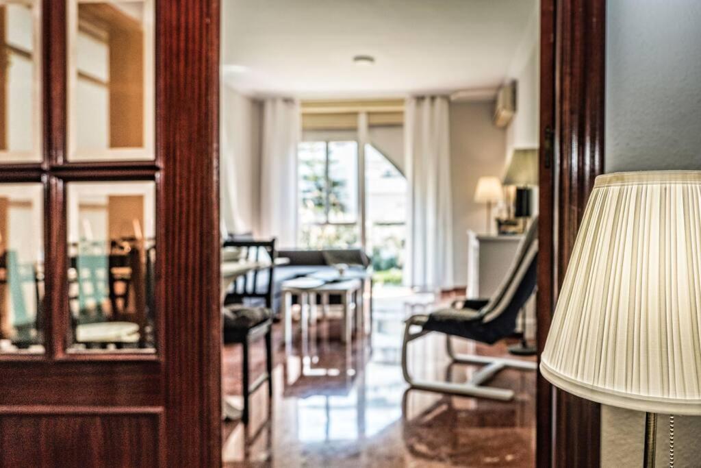塞维利亚Apartamento New Folch Sevilla A的客厅配有椅子、桌子和台灯