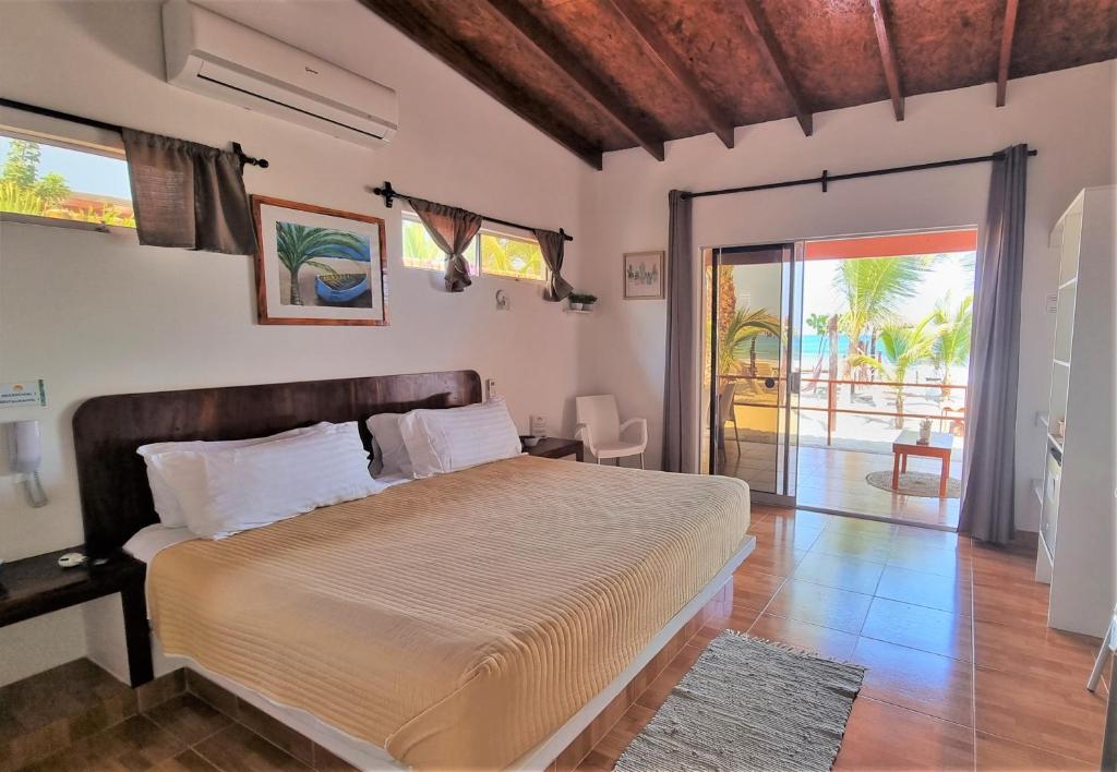 卡诺阿斯德蓬萨尔Punta del Norte Bungalows的一间卧室设有一张大床和一个滑动玻璃门