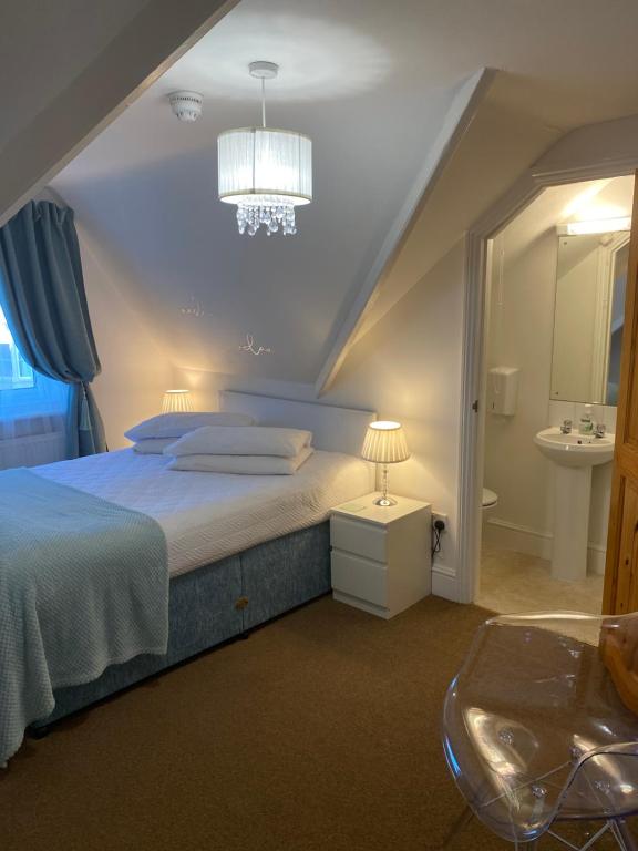 剑桥A & B Guest House Cambridge Ltd的一间卧室配有一张床、一个水槽和一个吊灯。