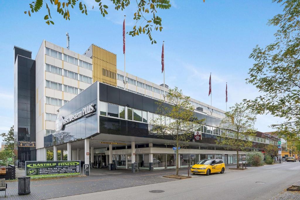 哥本哈根Best Western Plus Airport Hotel的停在大楼前的黄色汽车
