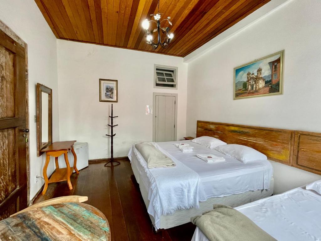 欧鲁普雷图自由之路旅馆的一间卧室设有两张床和木制天花板