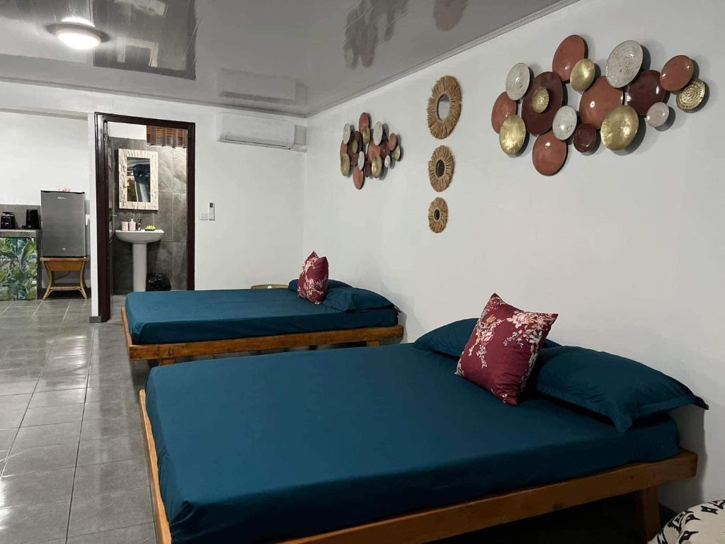 波拉波拉Bora Bora Hiva Home的配有蓝色床单的客房内的两张床