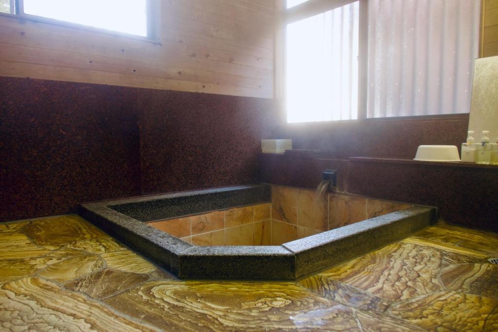 安昙野市天然温泉付き 北アルプスの麓安曇野 貸切一棟貸 70型スクリーン完備 フモトノイエ的一间带大浴缸及窗户的浴室