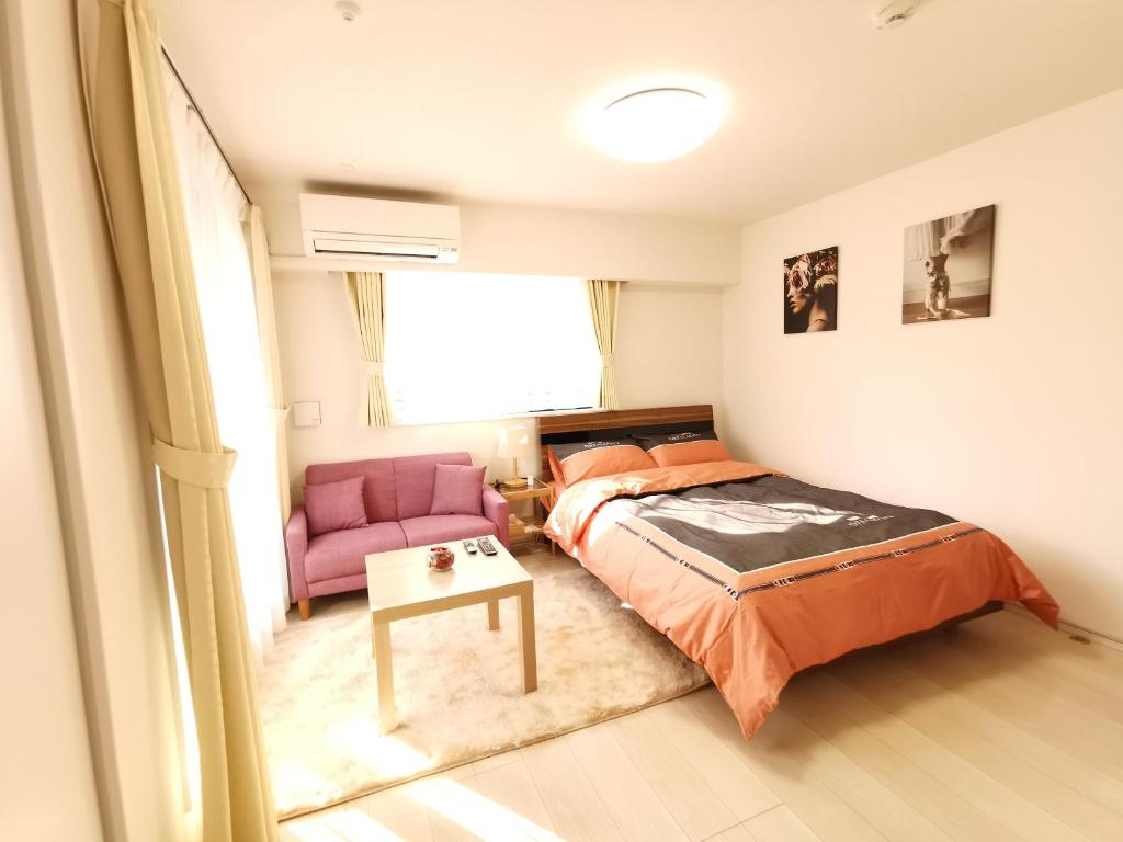 东京KIKI HOUSE 新小岩的一间卧室配有一张床和一张粉红色的椅子