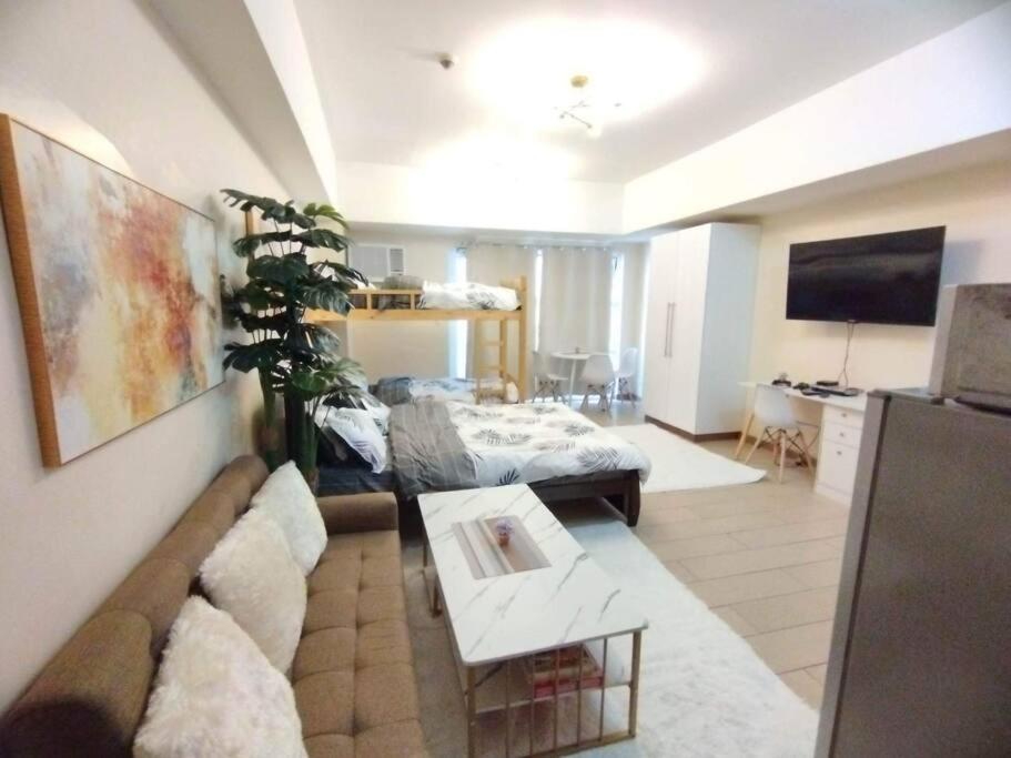 马尼拉A2J Luxury Venice Studio Suite Near BGC Malls的客厅配有沙发和桌子