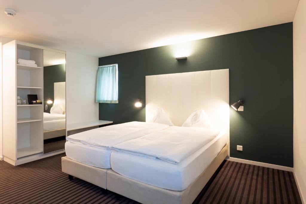 圣加仑Self Check-In Hotel David 22的卧室配有一张白色大床和镜子