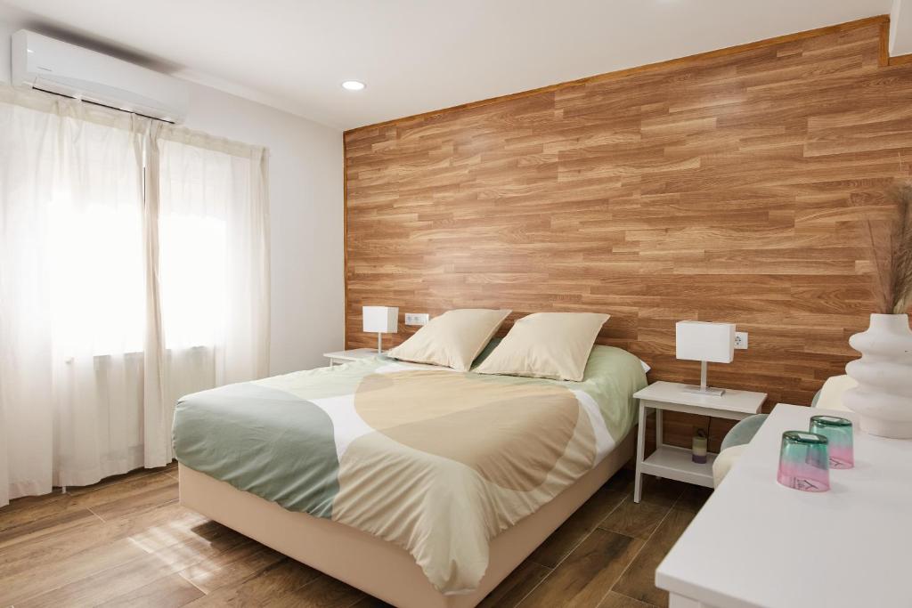 El CuervoEl Hortal i lloo的一间卧室设有木墙和一张床