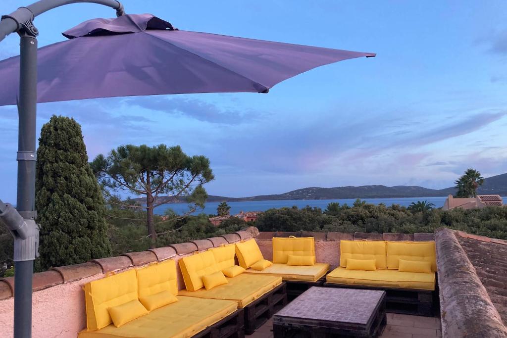 维琪奥港Grande Villa, Corse du Sud, Domaine privé de Cala Rossa的一个带沙发和遮阳伞的庭院