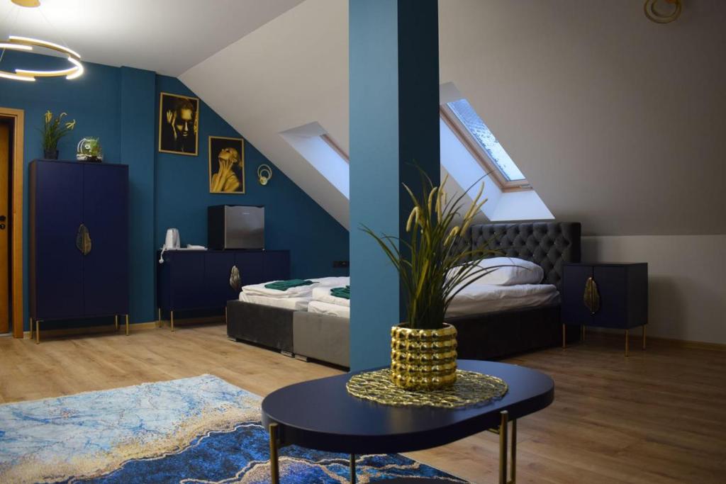 PodzamczeMały Książę的卧室拥有蓝色的墙壁,配有桌子和床