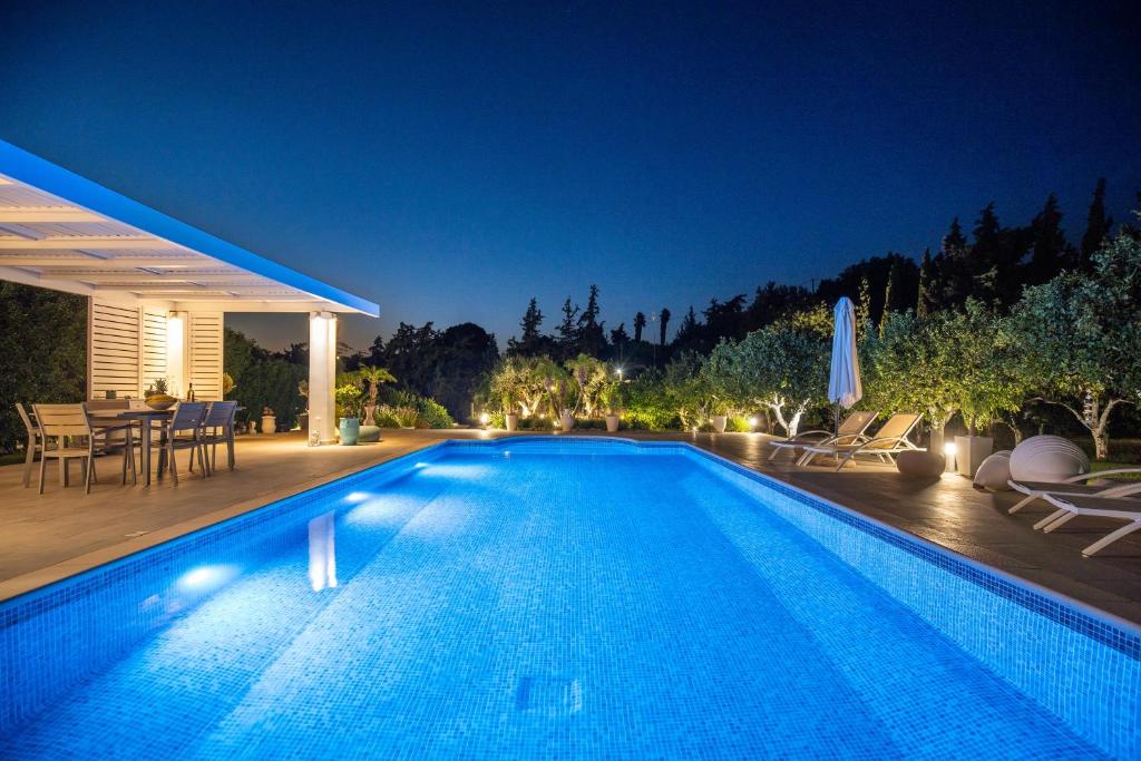 科斯基努Antigone Estate的夜间在房子前面的游泳池