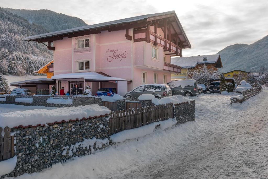 弗拉绍Landhaus Josefa的雪中带围栏的粉红色房子