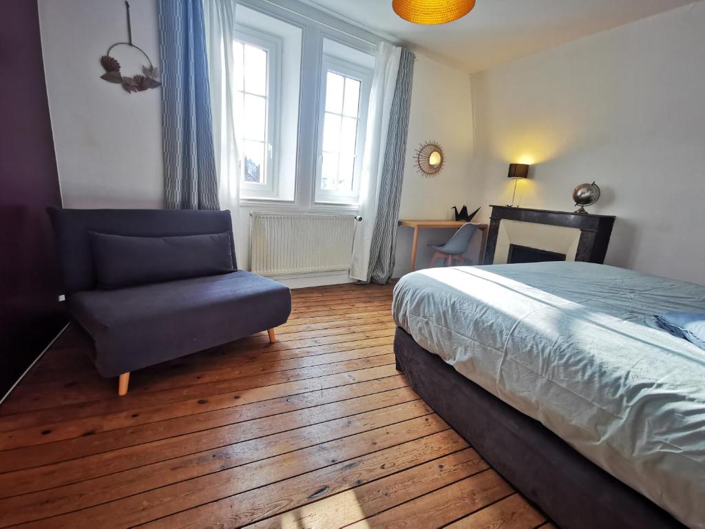 希农Maison au calme avec terrasse et jardin的一间卧室配有一张床、一把椅子和一张书桌