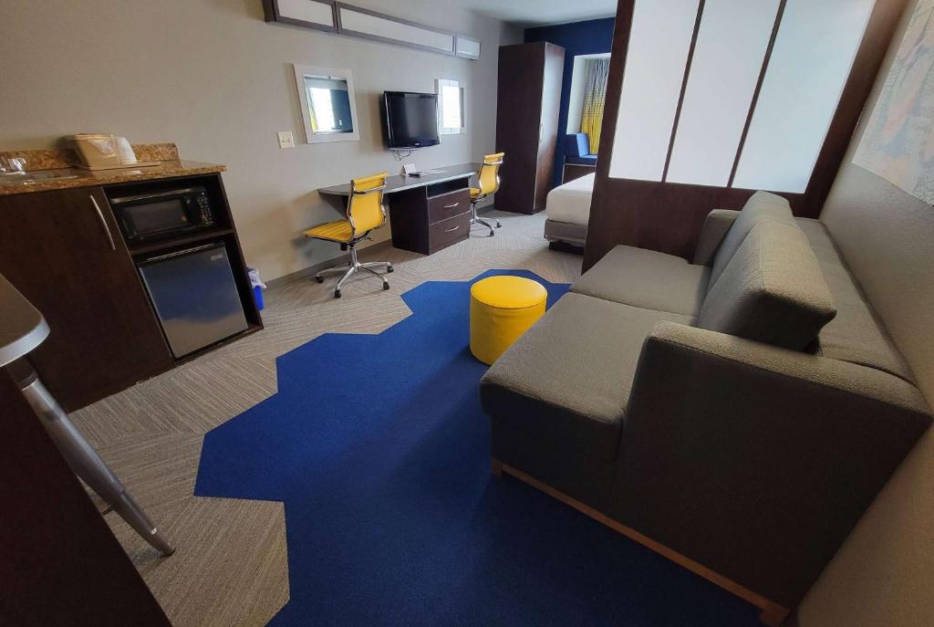 康瑟尔布拉夫斯布罗夫温德姆客栈&套房酒店的带沙发和蓝色地毯的客厅