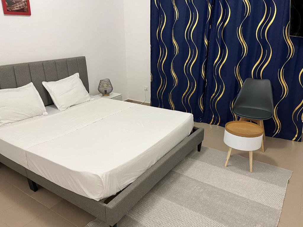 达喀尔Residence B&B Hibiscus的一间卧室配有一张床和一把椅子