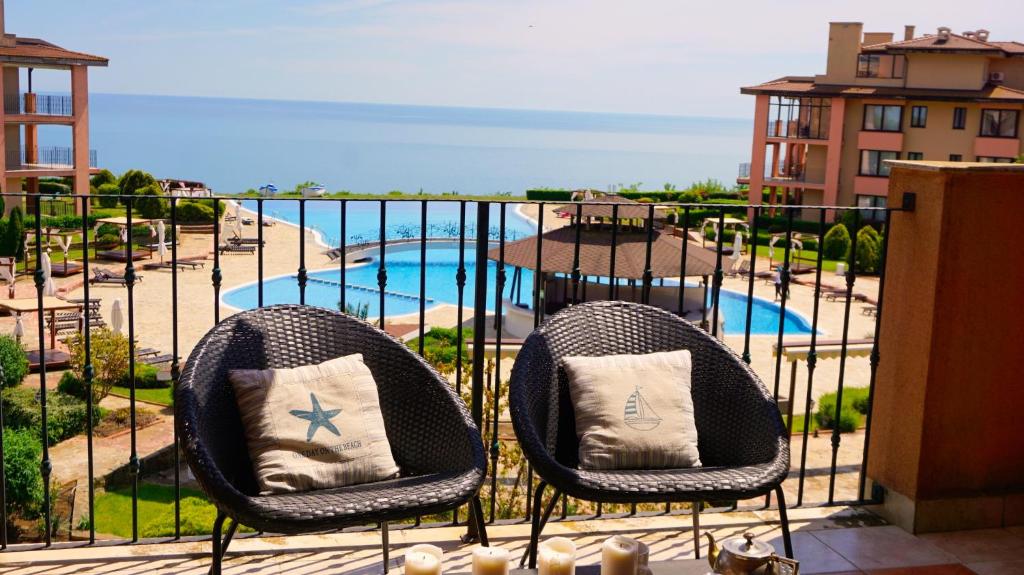 托波拉Apartment DECORA Sea View的阳台设有两把椅子,享有游泳池的景色