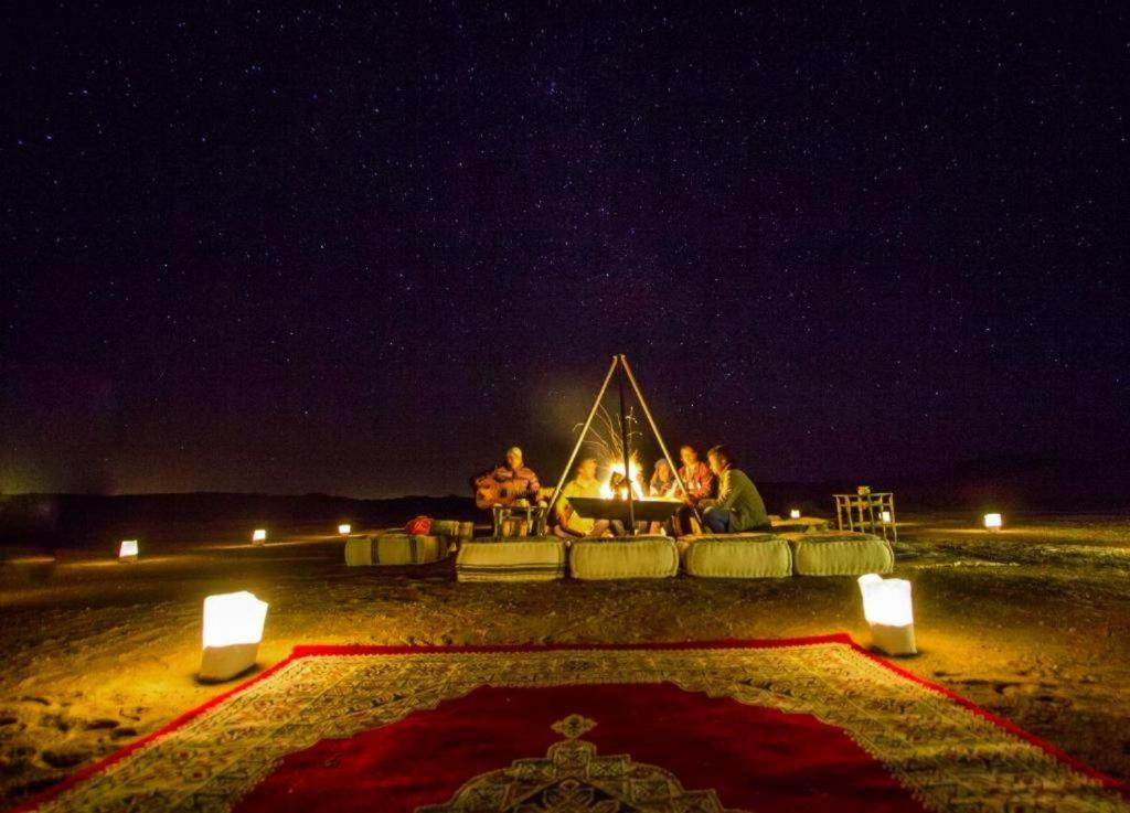 姆哈米德Chigaga Desert Camp的一群人晚上坐在火炉旁
