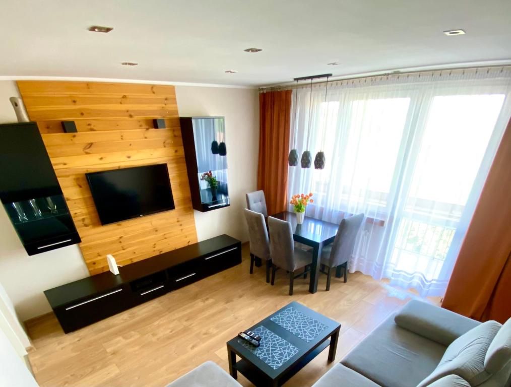 格利维采Apartament Glamour Work&Relax, obok ARENY Gliwice, FV的客厅配有沙发和带电视的桌子