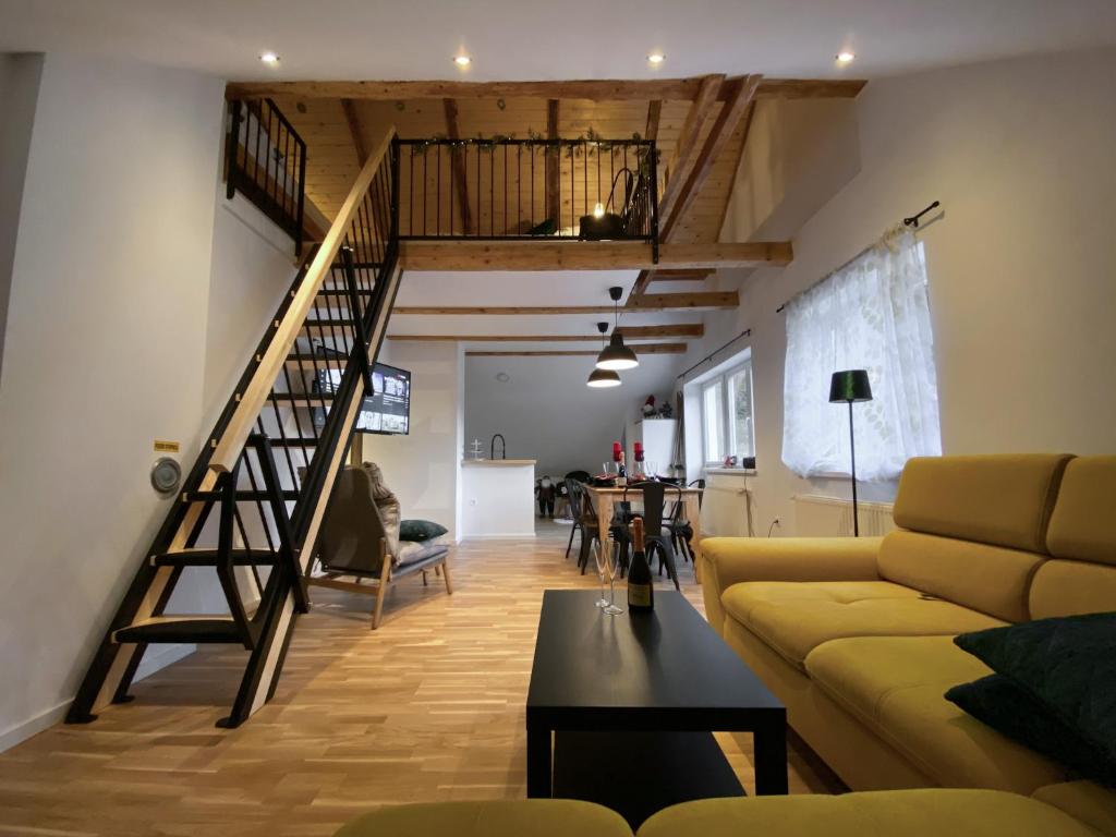 OplotnicaApartments Gozdni Raj Rogla的客厅设有楼梯和黄色沙发
