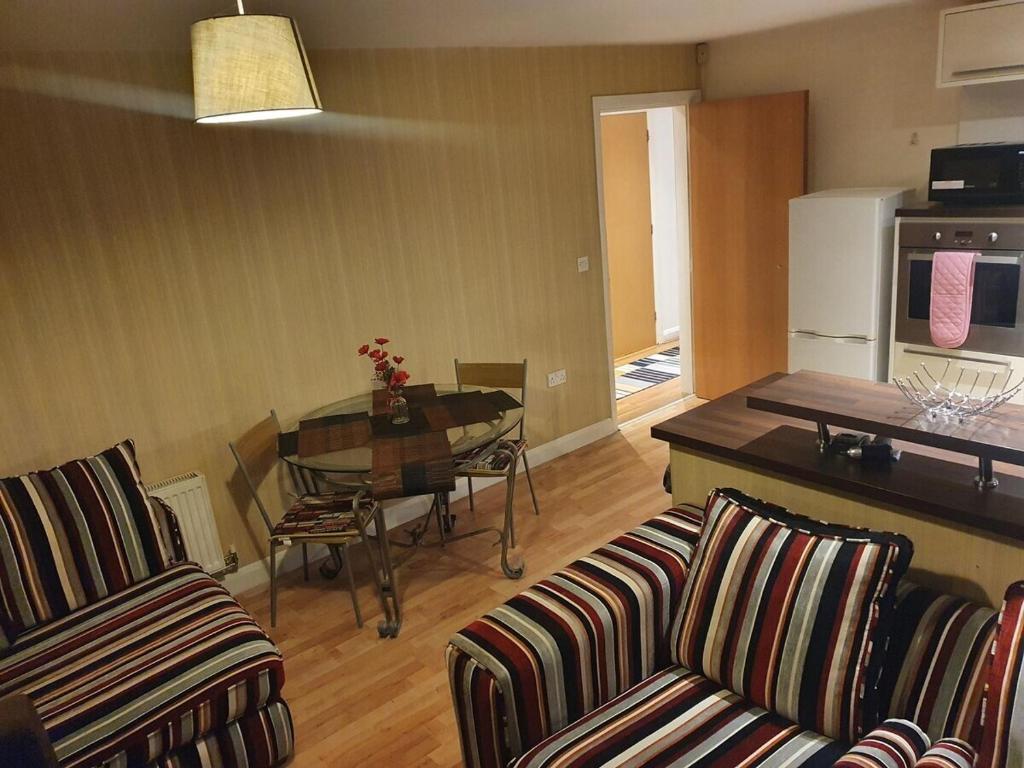 普雷斯顿Two Bedroom Apartment, Free parking, Close to UCLAN and free WIFI的一间带两把椅子和一张桌子的客厅以及一间厨房