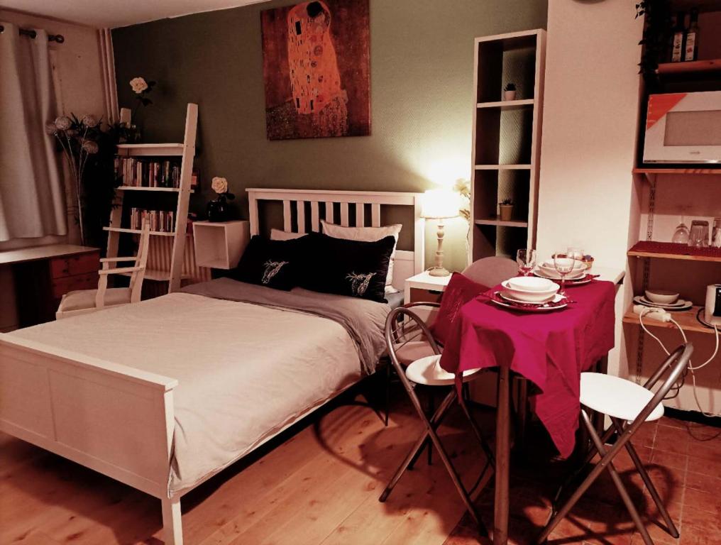 巴黎Super appartment at Paris的卧室配有一张床和一张桌子及椅子