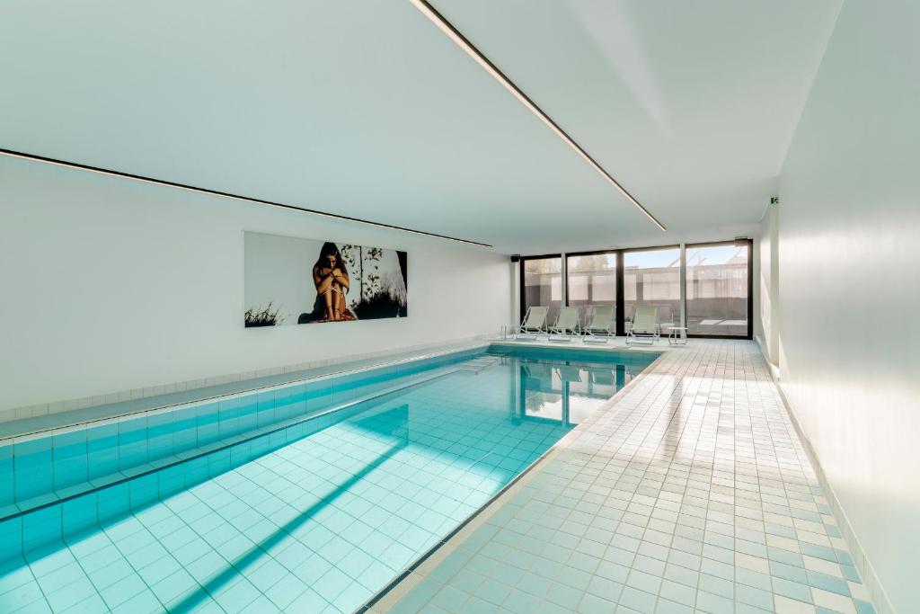 科克赛德Villa Paradis - De ultieme kustvilla met zwembad !的一座带大窗户的建筑中的游泳池