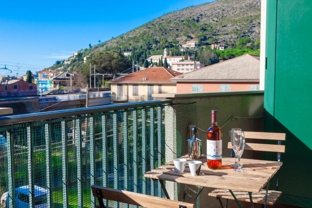 莱万托ANDREA Apartment的阳台上的桌子和一瓶葡萄酒