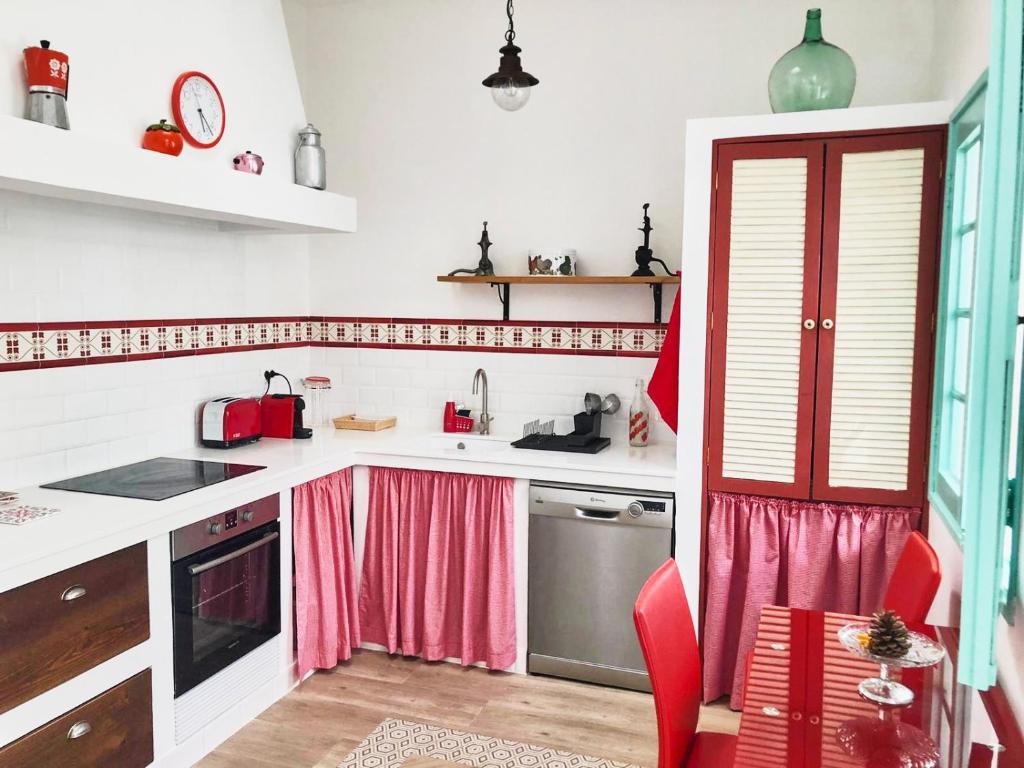 丰卡连特德拉帕尔马Casa Las Enanitas I - Casa Leo的厨房配有白色的柜台和粉红色的窗帘