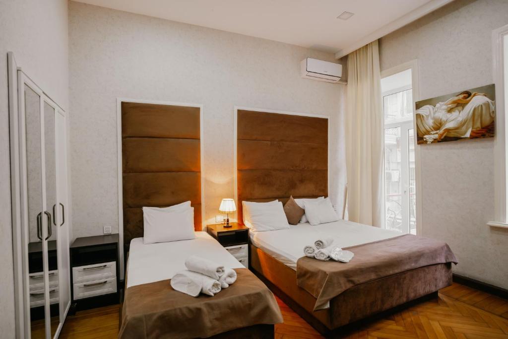 巴库City Inn Nizami Boutique Hotel的酒店客房,配有两张带毛巾的床