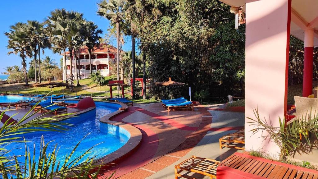 Bijilo莱蒙克里克度假酒店的一座位于度假村的游泳池,其背景是一座房子