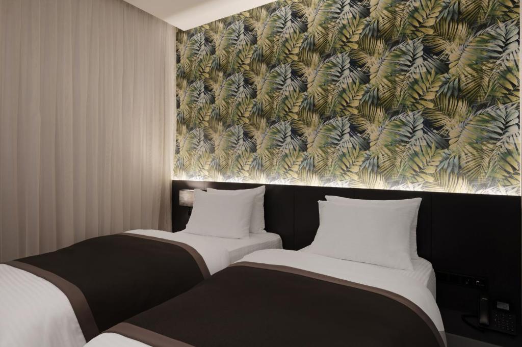 代胡克DDK Hotel Duhok的墙上画画的房间里设有两张床