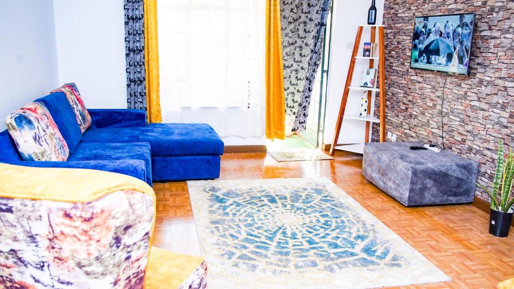 内罗毕Primal apartment at Embakasi, Nairobi, Kenya.的客厅配有蓝色的沙发和地毯。