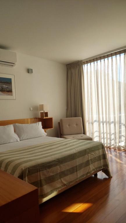 诺瓦海岸费昂达斯达利雅旅馆的一间卧室设有一张床和一个大窗户