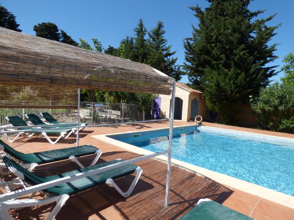 阿维尼翁Le Gîte du Festival Sud Aqua - Avignon TGV的房屋旁的游泳池设有躺椅和椅子