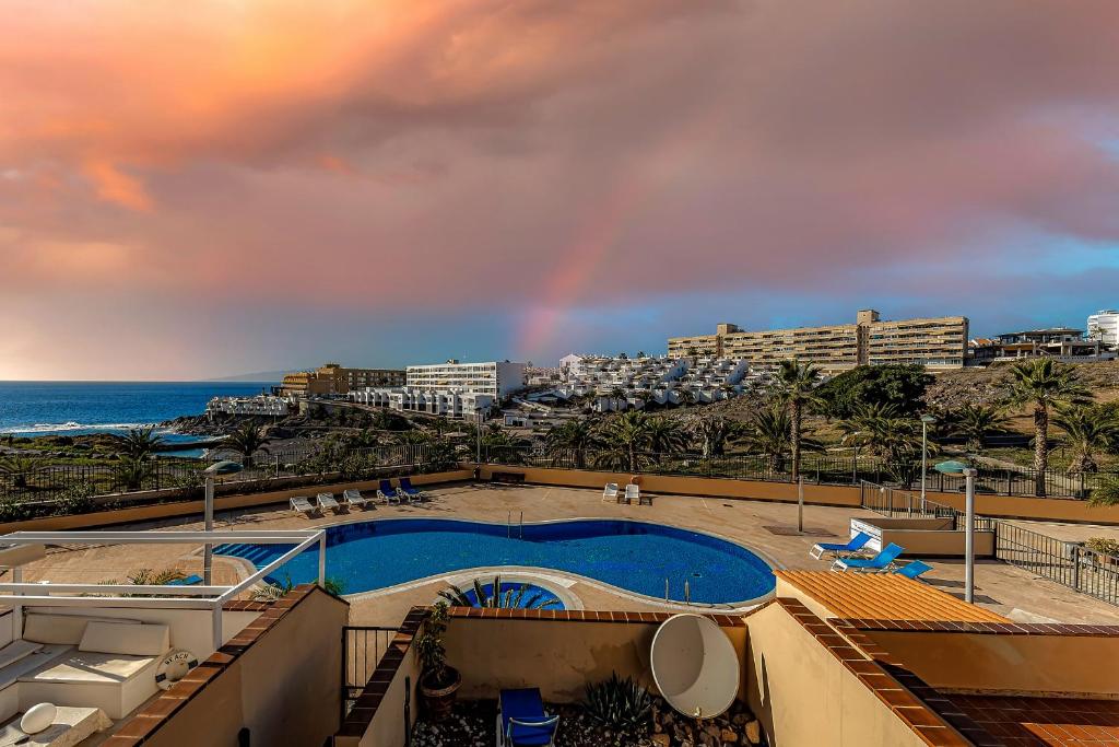 卡亚俄萨尔瓦赫Casa del Mar的天空中的一个彩虹,在游泳池和海洋上