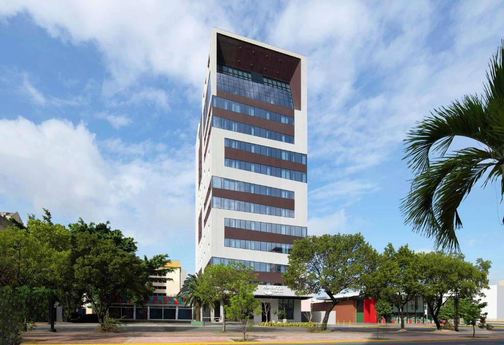 圣多明各Homewood Suites By Hilton Santo Domingo的一座高大的建筑,前面有一棵棕榈树