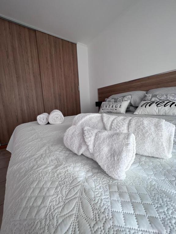 圣罗莎Luxury Spinetto的一张白色的床,上面有两条白色毛巾
