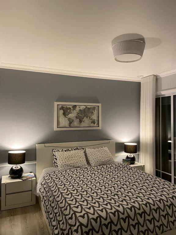 波瓦桑Modern room (with deck)的一间卧室配有一张大床和两盏灯。