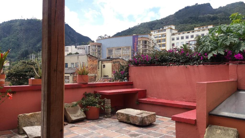 波哥大拉坎德拉里亚公寓式酒店的阳台设有红色长凳和一些植物