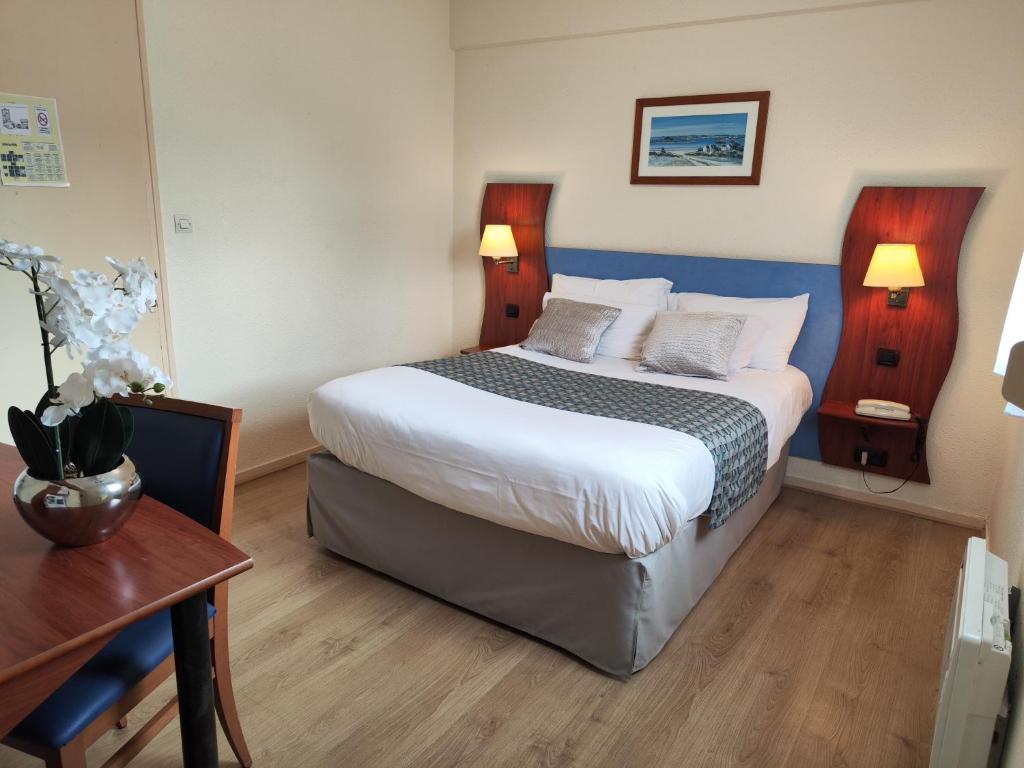 圣布里文莱丝皮恩河口酒店的酒店客房设有一张大床和一张桌子。