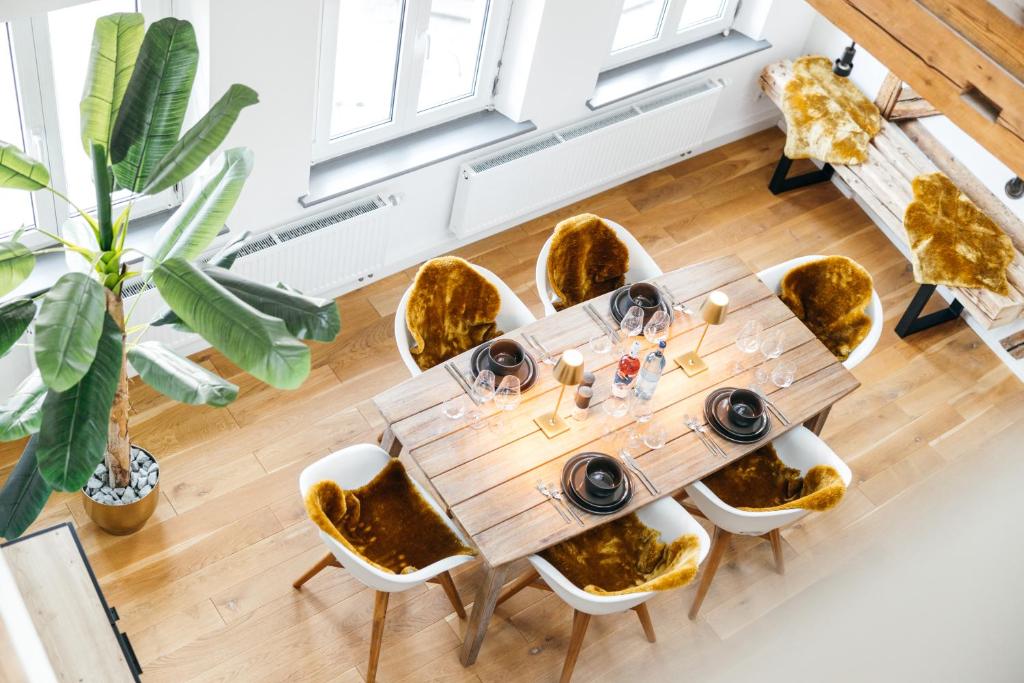 拉芬斯堡HEIMATEL - Luxury Penthouse Loft的一间带木桌和椅子的用餐室