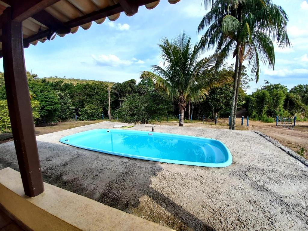 卡皮托利乌RANCHO PÉ DA SERRA的蓝色的游泳池,后面有棕榈树