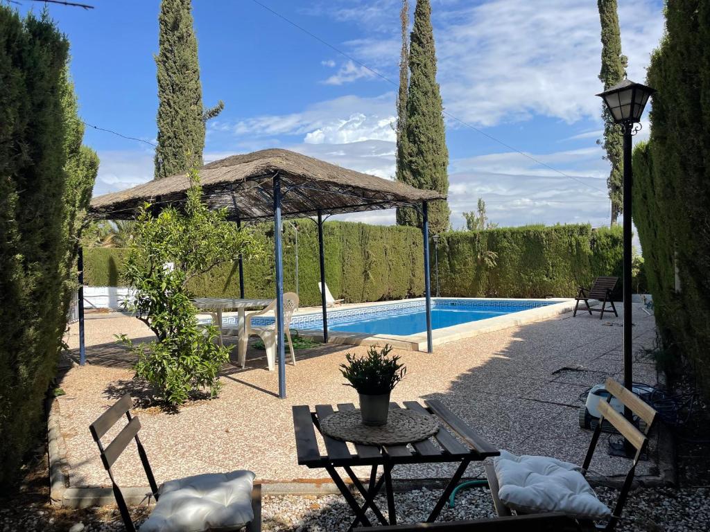 拉斯加比亚斯Granada Sights的一个带桌子和游泳池的庭院